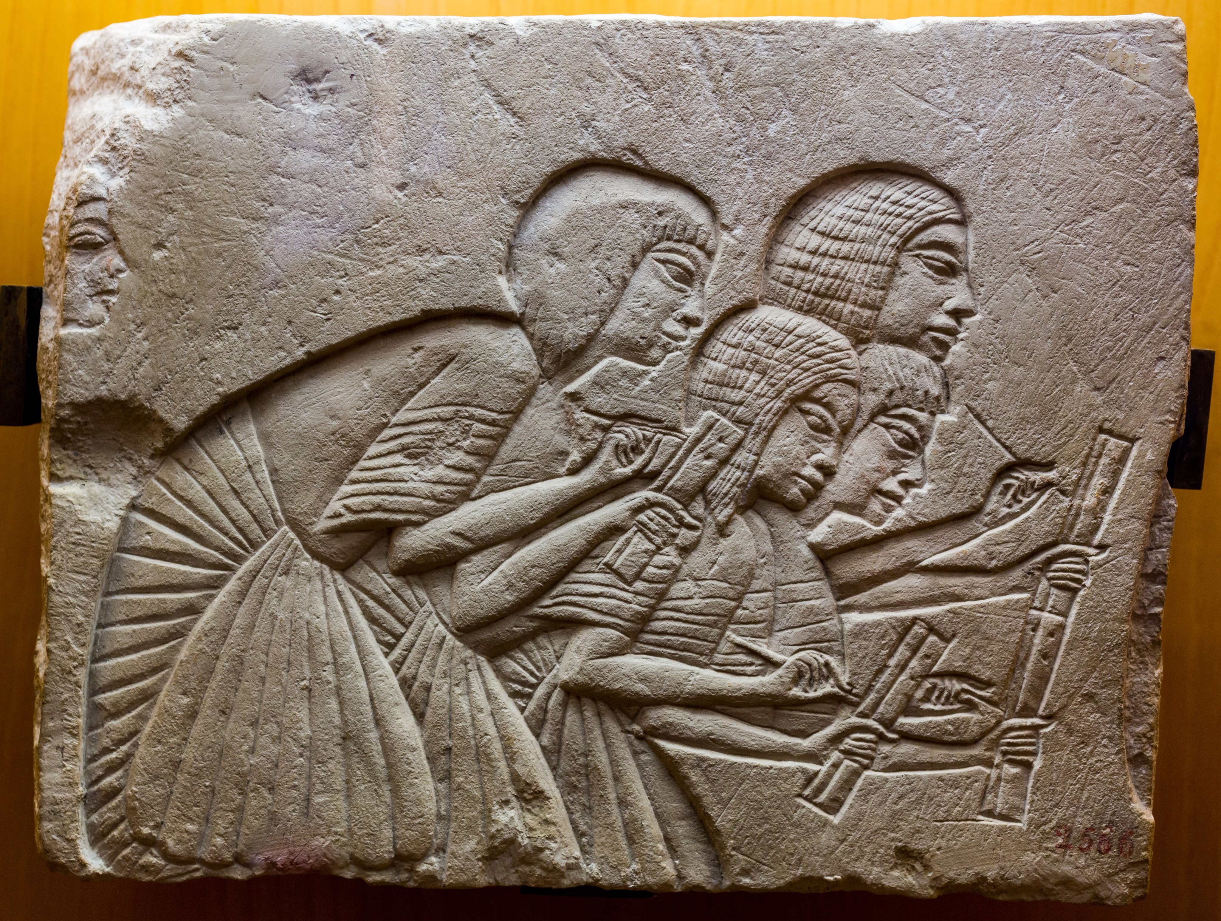 Quatre scribes, se penchant, écrivant quelque chose dicté par le pharaon (conservé dans un autre fragment, dans le musée de Leiden, Pays-Bas) / ArchaiOptix, CC BY-SA 4.0
